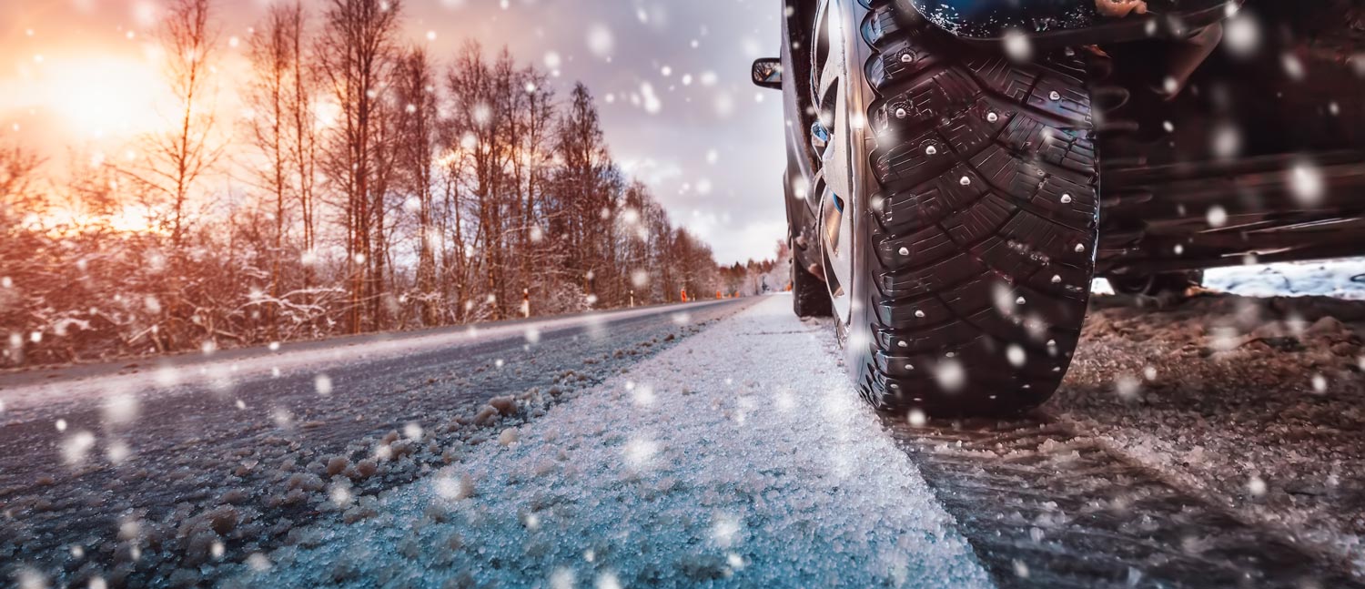 close up of car driving on snowy road and wheel alignment