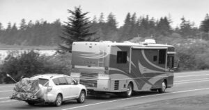 Rv towing a vehicle driving on a road