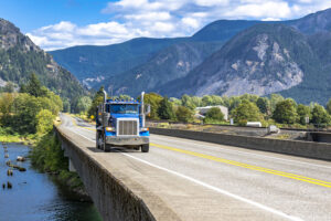 commercial truck driving on highway in mountains